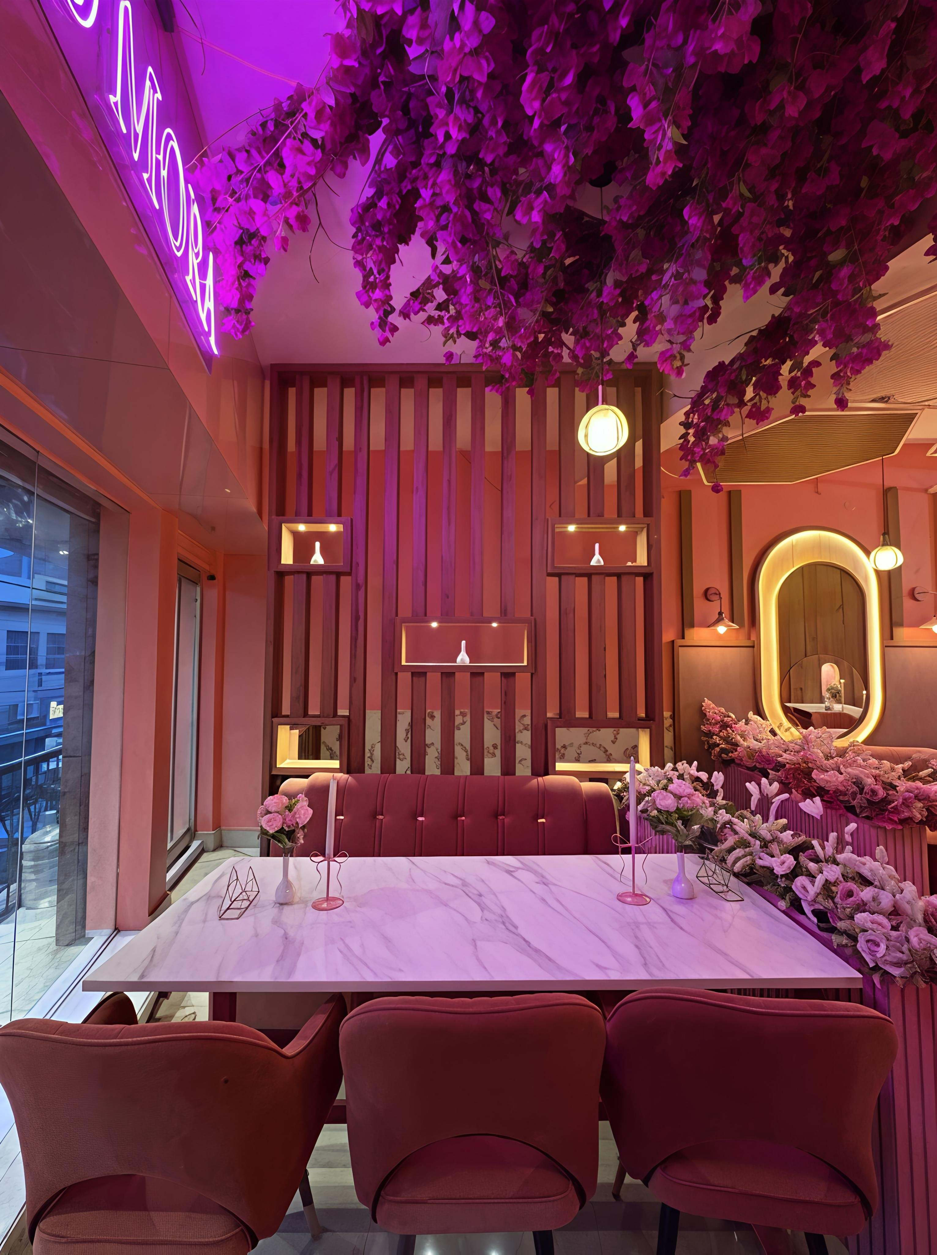 Family table under the bougainvillea canopy and neon Bloomora glow